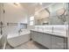 Luxurious bathroom featuring a soaking tub, double vanity, and sleek, modern design at 2702 Oxborough Dr, Matthews, NC 28105
