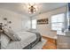 Cozy bedroom with light wood floors, natural light, a ceiling fan, and sports-themed decor at 2702 Oxborough Dr, Matthews, NC 28105