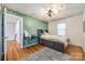 Unique bedroom with wood floors and an accent wall; a compact desk allows for study at 2702 Oxborough Dr, Matthews, NC 28105