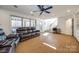 Open-concept living room features a leather sofa and a large picture window showcasing outside views at 2702 Oxborough Dr, Matthews, NC 28105