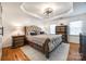 Cozy main bedroom with a tray ceiling, hardwood floors and stylish accent furniture at 2702 Oxborough Dr, Matthews, NC 28105