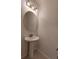 Stylish bathroom with a pedestal sink, round mirror, and modern lighting at 2716 Rea Rd, Charlotte, NC 28226