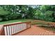 Newly stained deck overlooks a sport court with mature trees offering a serene outdoor space for enjoyment at 2716 Rea Rd, Charlotte, NC 28226