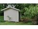 Exterior shot of a storage building with neutral siding and white trim nestled among lush greenery at 2716 Rea Rd, Charlotte, NC 28226