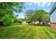 Large grassy backyard with well maintained lawn, and mature trees at 2968 Grace St, Claremont, NC 28610
