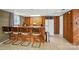 Basement bar area featuring wood paneled walls, a sink, a refrigerator, and bar stool seating at 2968 Grace St, Claremont, NC 28610