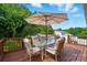 Inviting outdoor deck featuring a dining set with umbrella coverage, surrounded by lush greenery and bright blue skies at 2968 Grace St, Claremont, NC 28610