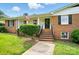 Inviting brick front entrance with neat landscaping, black shutters, and American flag waving above at 2968 Grace St, Claremont, NC 28610
