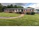 Charming brick home featuring a well-manicured lawn, covered side porch, and inviting front entrance at 2968 Grace St, Claremont, NC 28610