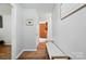 Inviting hallway with light gray walls, hardwood floors, and a bench seat at 2968 Grace St, Claremont, NC 28610