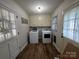 Laundry room with updated washer and dryer, overhead cabinets, and wood look flooring at 2968 Grace St, Claremont, NC 28610