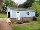 Exterior of a light blue detached outbuilding with a red brick foundation and a gray roof at 2968 Grace St, Claremont, NC 28610