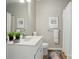 Well-lit bathroom with white vanity, neutral wall art, and a shower with white curtain at 31415 Royal Tern Ln, Fort Mill, SC 29707