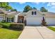 Inviting exterior of townhome with mature landscaping, attached two-car garage, and brick accents at 31415 Royal Tern Ln, Fort Mill, SC 29707