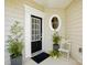 Inviting front entryway with decorative front door, round window, and stylish potted plants at 31415 Royal Tern Ln, Fort Mill, SC 29707