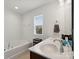 Bathroom featuring bathtub, window, and double vanity with wood cabinets at 3306 Yarmouth Ln, Gastonia, NC 28056