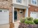 Charming front entrance with brick accents, an emerald door, a small garden, and a garage at 3306 Yarmouth Ln, Gastonia, NC 28056