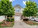 Charming townhome showcasing manicured landscaping, neutral brick, and a driveway leading to the attached garage at 3306 Yarmouth Ln, Gastonia, NC 28056