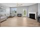 Bright living area featuring modern gray paint, natural light, and a fireplace with glass door to backyard at 3306 Yarmouth Ln, Gastonia, NC 28056