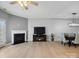 Spacious living room with a ceiling fan, fireplace, and seamlessly connected to the dining area with modern light fixture at 3306 Yarmouth Ln, Gastonia, NC 28056