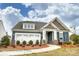 Charming single-Gathering home with blue siding, stone accents, and a well-manicured front lawn at 3315 Whispering Creek Dr # 95, Wesley Chapel, NC 28079
