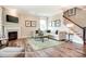 Bright living room features wood floors, fireplace, staircase, and comfortable seating at 3315 Whispering Creek Dr # 95, Wesley Chapel, NC 28079
