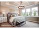 Well-lit main bedroom featuring a tray ceiling, chandelier, and large windows at 3315 Whispering Creek Dr # 95, Wesley Chapel, NC 28079