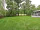 Expansive backyard featuring lush lawn and mature trees providing a private and serene setting at 3409 Valdosta Ct, Monroe, NC 28110
