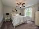 Bedroom showcasing a bed with a ceiling fan, window, bedside tables, and neutral decor at 3409 Valdosta Ct, Monroe, NC 28110