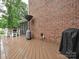 View of the outdoor deck with patio heater, grill and exterior brick wall at 3409 Valdosta Ct, Monroe, NC 28110