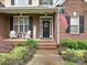 Inviting front porch with American flag, chairs, and manicured landscaping at 3409 Valdosta Ct, Monroe, NC 28110