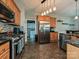 Shows the stainless fridge, tile flooring, stainless stove, and wooden cabinetry at 3409 Valdosta Ct, Monroe, NC 28110