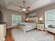 Shows the spacious main bedroom, tray ceiling, ceiling fan, and natural light from the window at 3409 Valdosta Ct, Monroe, NC 28110