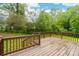 Wooden deck with brown railings overlooking the lawn and mature trees at 3716 Hamilton Dr, Gastonia, NC 28052
