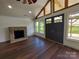 Living room featuring a fireplace, hardwood floors, and a vaulted ceiling at 401 Constant Ln, Charlotte, NC 28722
