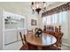 Charming dining area features a round wood table, chandelier, and a laundry closet with washer and dryer at 4044 Murray St, Indian Land, SC 29707