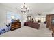 Spacious living room with a brown leather sofa, wooden dresser, and large window with shutters at 4044 Murray St, Indian Land, SC 29707