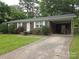 Lovely brick home showcasing a well-kept lawn and attached carport for convenient parking at 409 Anne Ave, Waxhaw, NC 28173