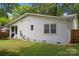 View of the back of the home showing white siding and a fenced in yard at 4106 Castlewood Rd, Charlotte, NC 28209