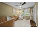 Bright Bedroom features crib, changing table on dresser, comfortable chair, overhead fan, and natural light at 4106 Castlewood Rd, Charlotte, NC 28209