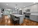 Stylish kitchen with white upper cabinets, stainless steel appliances, island seating, and hardwood floors at 4106 Castlewood Rd, Charlotte, NC 28209