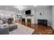 Bright living room showcasing a fireplace, hardwood floors, and open layout to kitchen and dining areas at 4106 Castlewood Rd, Charlotte, NC 28209