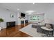 Cozy living room featuring hardwood floors, a brick fireplace, and stylish furnishings at 4106 Castlewood Rd, Charlotte, NC 28209