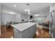 Open concept living room showcasing kitchen island, dining area, and living room with fireplace and hardwood floors at 4106 Castlewood Rd, Charlotte, NC 28209