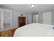 Neutral bedroom featuring hardwood floors, ceiling fan, dresser, and doorways leading to bathroom and closet at 4106 Castlewood Rd, Charlotte, NC 28209