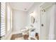 Bathroom with white tile shower, a pedestal sink, shuttered window, and wood-look flooring at 501 E Tremont Ave, Charlotte, NC 28203