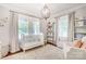 Bright Bedroom with a white crib, shelving for toys, and a chandelier at 501 E Tremont Ave, Charlotte, NC 28203