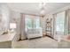 Bright Bedroom with a white crib, shelving for toys, a chandelier and a dresser at 501 E Tremont Ave, Charlotte, NC 28203