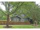 Charming home featuring a fenced-in yard with mature trees and a green lawn at 501 E Tremont Ave, Charlotte, NC 28203