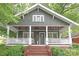 Charming home showcasing a welcoming front porch with white railings and a red brick staircase at 501 E Tremont Ave, Charlotte, NC 28203
